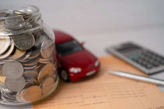 Car with coins in glass jar; car loan, finance, saving money, banking, insurance and leasing time concepts.