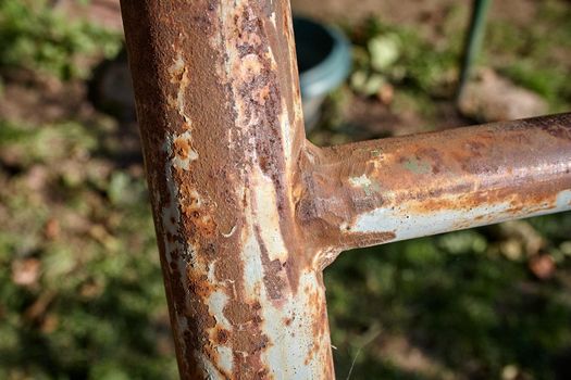 Rusty iron pole as part of a metal staircase. Close-up