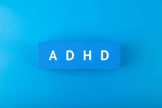 Minimal modern concept of Adhd in blue color. Top view of block with written Adhd words against blue background