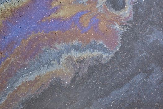 Oil stain on Asphalt, color Gasoline fuel spots on Asphalt Road as Texture or Background. Marbleized effect.