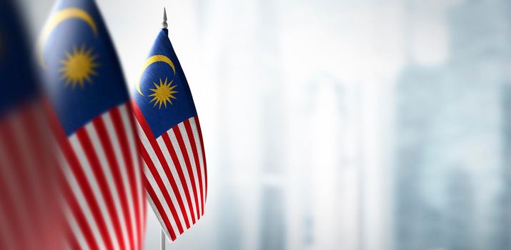 Small flags of Malaysia on a blurry background of the city.