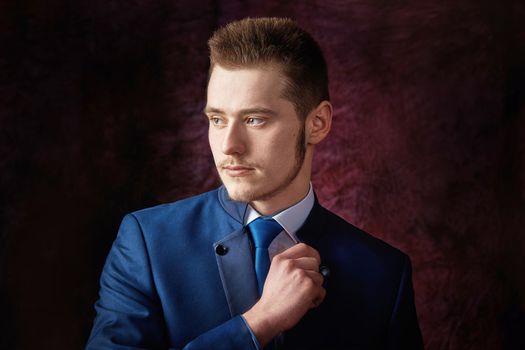 A man dressed in a suit over dark grey background.