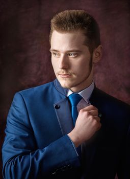 A man dressed in a suit over dark grey background.