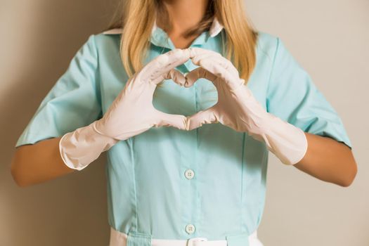 Image of medical nurse showing heart shape with hands.