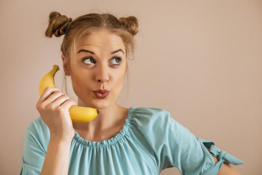 Portrait of cute playful woman holding banana.