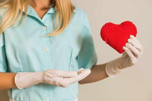 Image of medical nurse holding red heart.