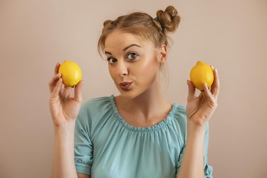 Portrait of cute blonde woman holding lemon.Toned image.