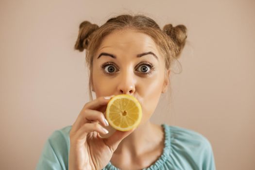 Close up portrait of cute woman  holding slice of lemon.Toned image.