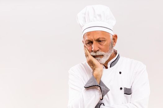 Image of sad chef on gray background.