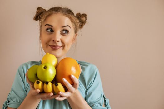 Portrait of cute happy woman holding bunch of fruit.Toned image.