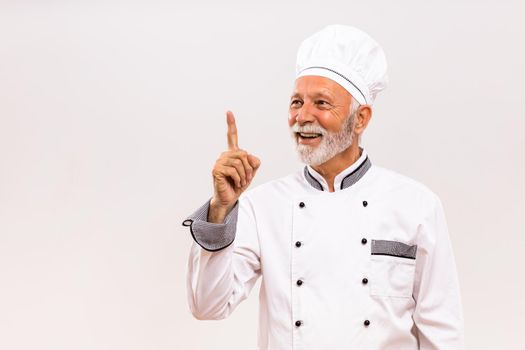 Portrait of happy senior chef having idea.