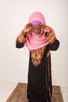 Young muslim african woman wearing veil in prayer gesture, praying god isolated on white background