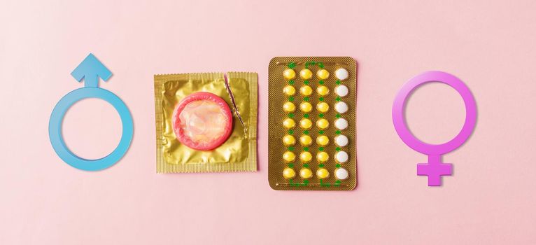 World sexual health or Aids day, condom on wrapper pack, contraceptive pills blister hormonal birth control pills and Male, female gender signs on a pink background, Safe sex and reproductive health