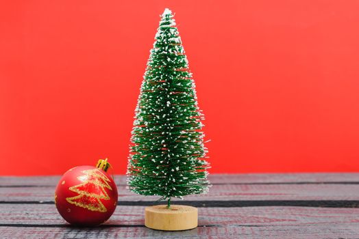 Christmas composition decorations, minimal green fir tree branches with snow and ball on red background. Merry Christmas concept. Copy space for text