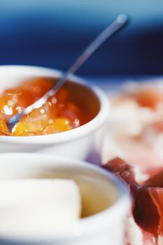 Breakfast outdoors in summer, ham, jam, butter and ham.