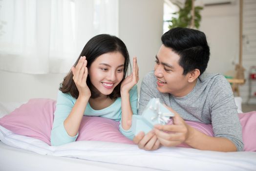 Young couple in love make a present to each other on Valentine's Day.
