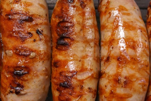 homemade juicy grilled sausages on a grill pan close-up. Cooking food