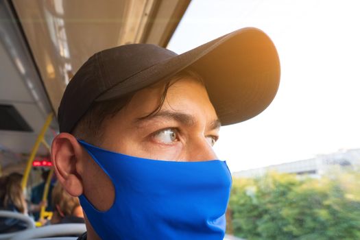 Portrait of a young man in a mask on a bus. Travel by public transport by bus