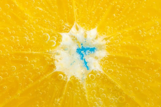 Orange fruit in water close up, under water with bubbles. Slow motion