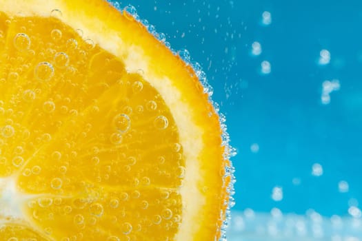 Orange fruit in water close up, under water with bubbles.