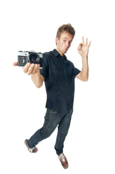Young man standing with film camera isolated on white background