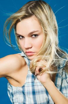 Portrait on sensual blond girl over blue background