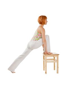 Red haired girl performing fitness exercises on white background