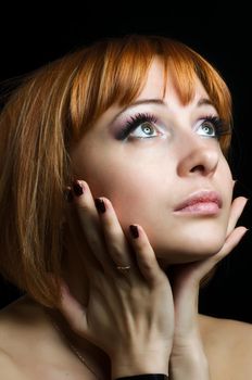 Beauty portrait of red girl on black background