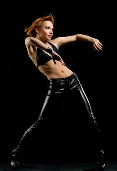 Studio shot of beautiful red dancer on black background