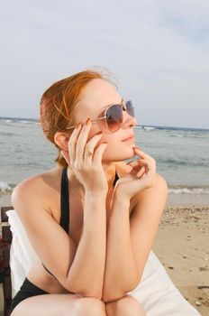 Beautiful red girl enjoying her rest at the beach