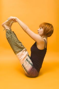 Agile red girl performing yogatic asanas over vibrant background