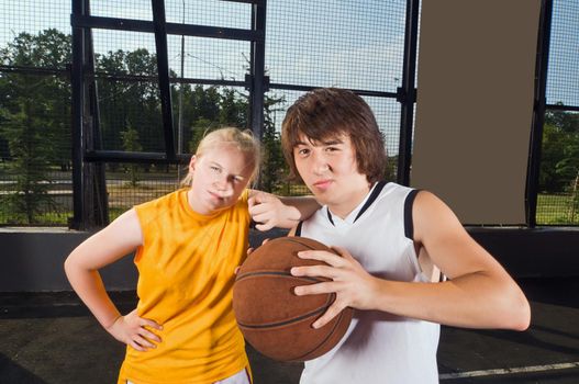 Two teenage basketball players posing at the outdoor playground