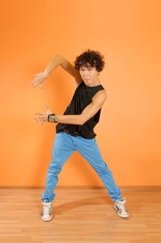 Young man perform break dancing moves on vivid background