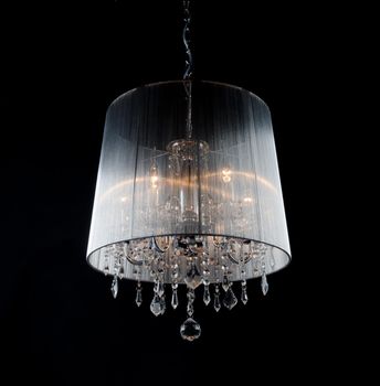 Contemporary chandelier with crystals isolated over black background