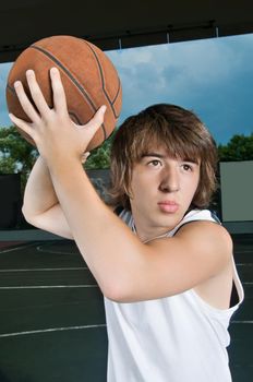 Cool asian boy with basketball at streetball playground