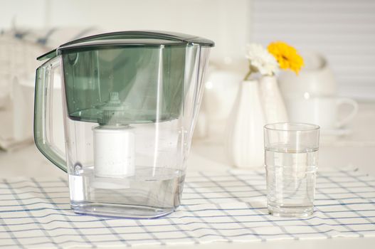 Water filter and a glass at the kitchen table
