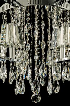 Closeup of contemporary glass chandelier isolated over black background