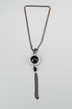 Silver necklace with pendant shot on gray background