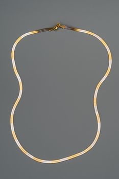 Luxury golden necklace on gray background