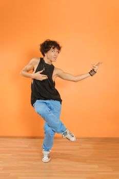 Young man perform break dancing moves on vivid background