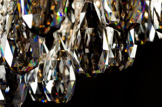 Contemporary glass chandelier crystals isolated over black background