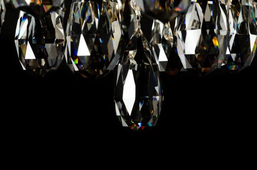 Contemporary glass chandelier crystals isolated over black background