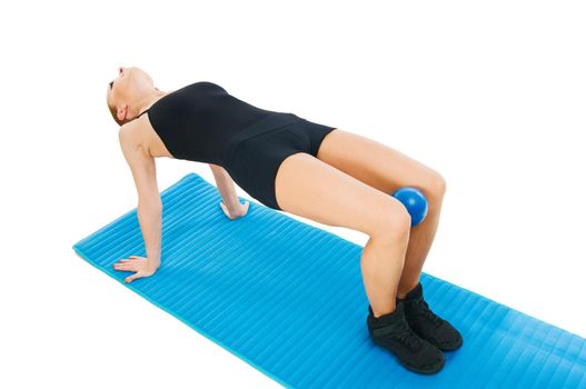 Beautiful fit red girl practicing pilates or callanetics with ball and blue yoga mat