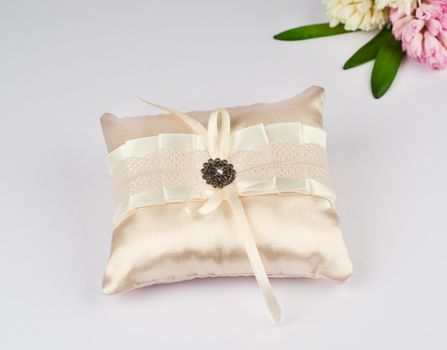 Exquisite pillow for wedding rings on gray background