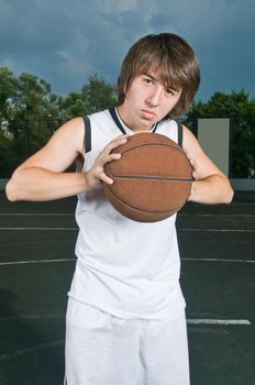 Teenage basketball player holding the ball ready to pass