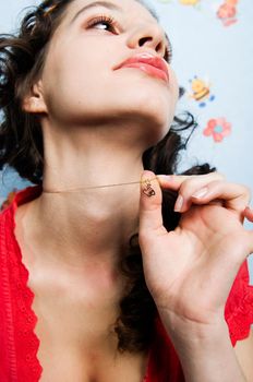 Girl holding heart-shaped pendant thinking about her love