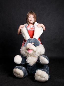Little girl playing with a toy bunny