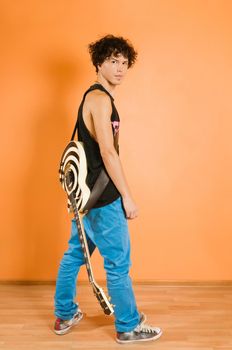 Young performer posing with guitar at the vivid background