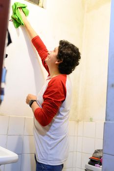 man cleaning white wall before painting while renovating interior