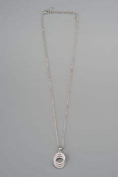 Silver necklace with pendant shot on gray background